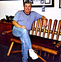 Dave Ariss sits on his one of a kindbaseball memorabilia bench.